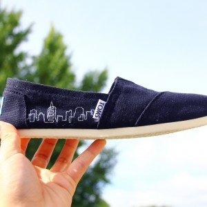 Custom, hand painted City Skyline TOMS shoes featuring a vector line art of a city skyline.