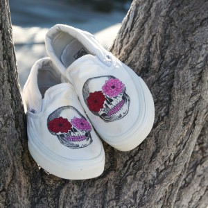 Custom, hand painted Floral Skull Vans slip on shoes featuring detailed illustrated skulls with flowers and pink teeth.