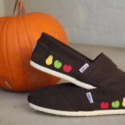 Custom, hand painted Fruits TOMS shoes featuring a green apple, a red apple, and a golden pear on either side.