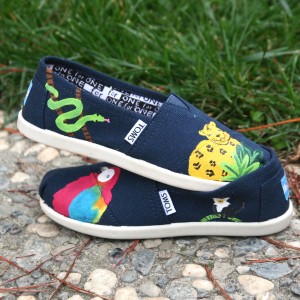 Custom, hand painted Rainforest youth TOMS shoes featuring a scarlet macaw parrot, lemur, jaguar, and snake in a tropical rainforest.