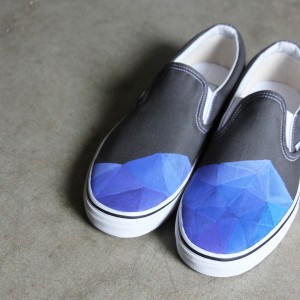 Custom, hand painted Low Poly Vans slip on shoes featuring a blue toned gradient of low poly triangles.